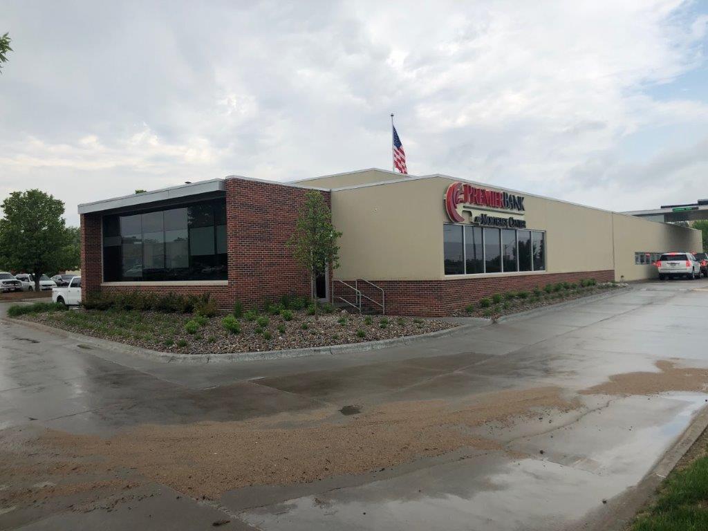 A large building with a lot of windows and a parking lot in front of it.