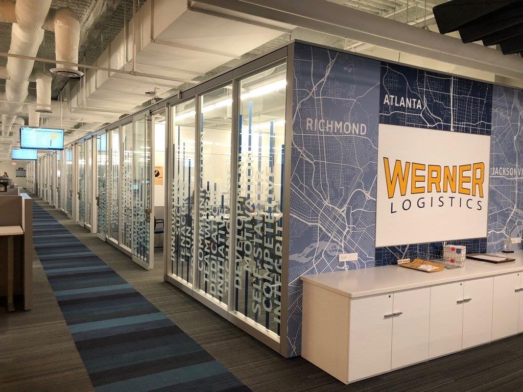A hallway in an office with a sign that says werner logistics