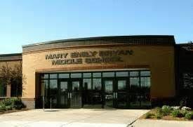 A large brick building with a glass door and a sign that says mary emily bryan middle school.