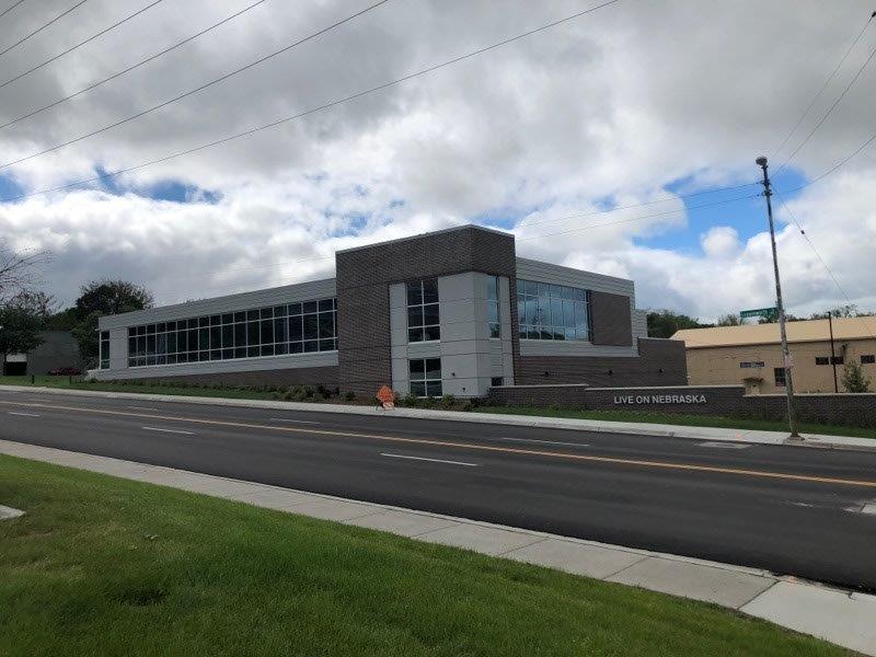 A large building with a lot of windows is next to a road