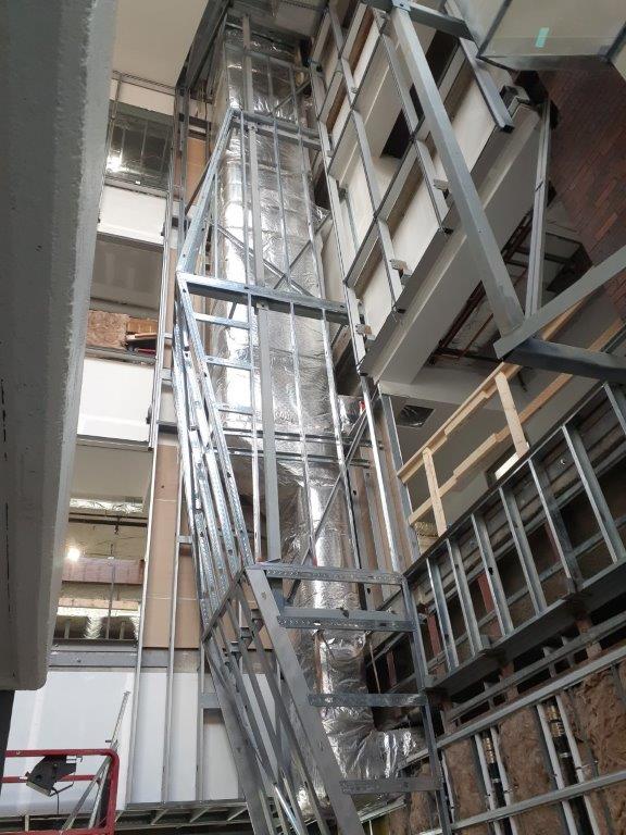 A metal staircase is being built in a building