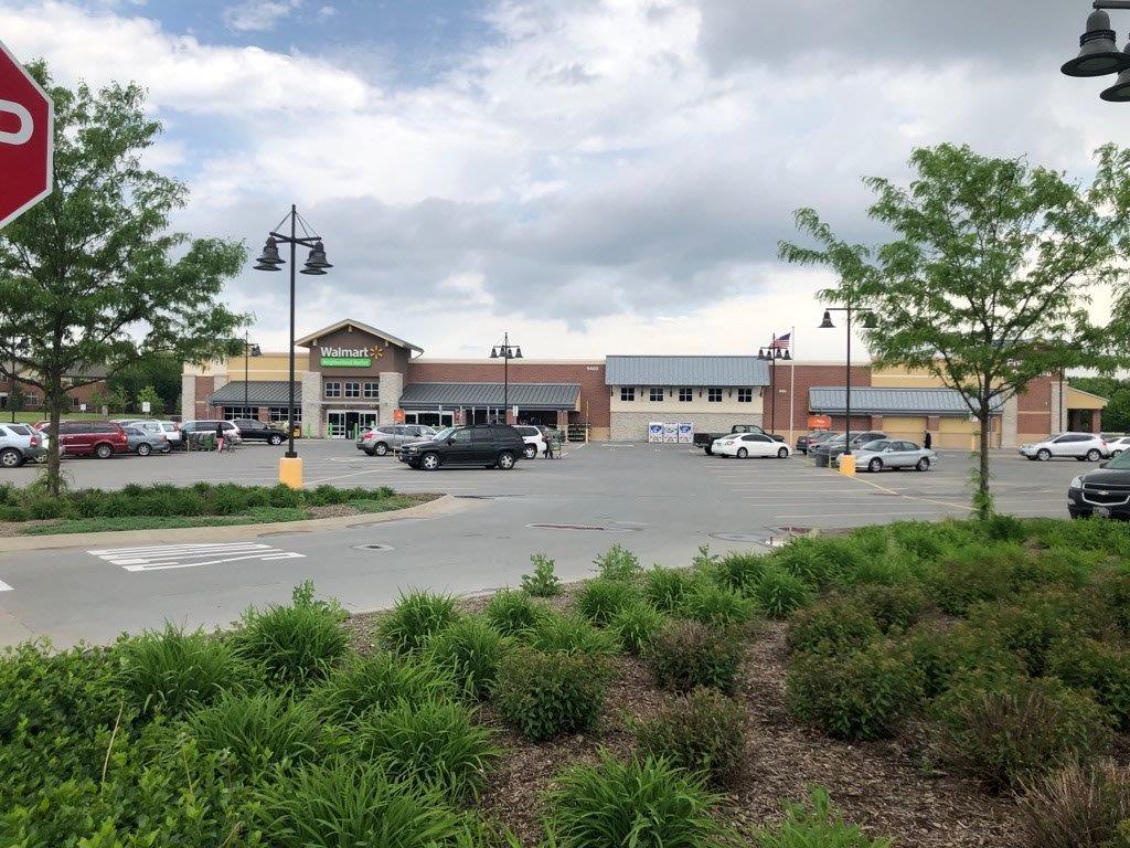 A stop sign is in front of a parking lot in front of a store.