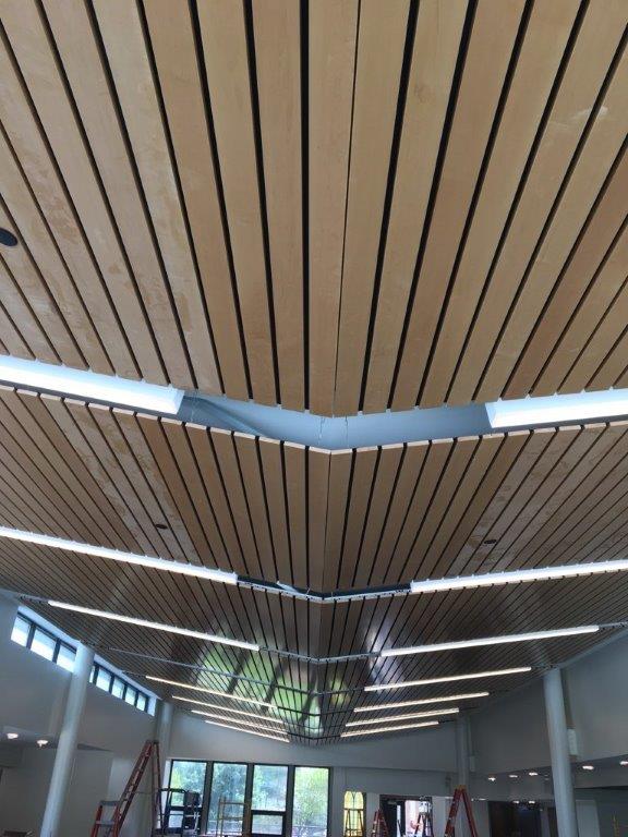 A large room with a wooden ceiling and lots of windows