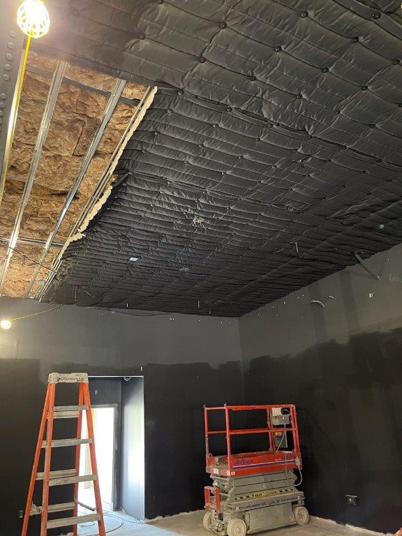 A room with a ladder and a scissor lift in it.