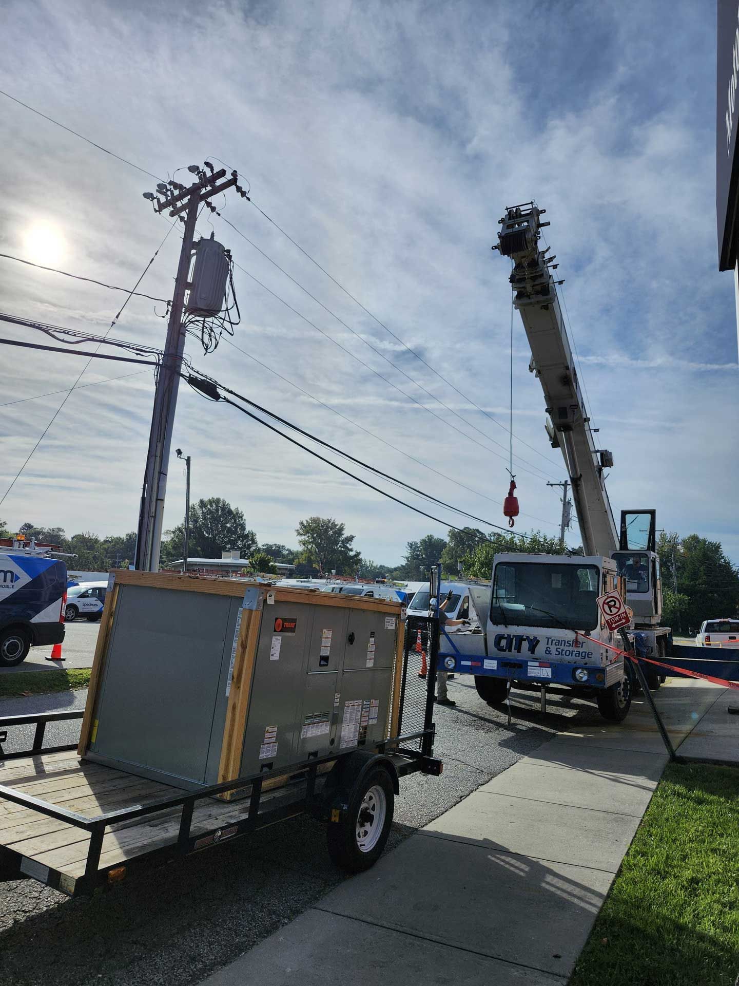 HVAC crews work beside a street, with a truck and equipment nearby.