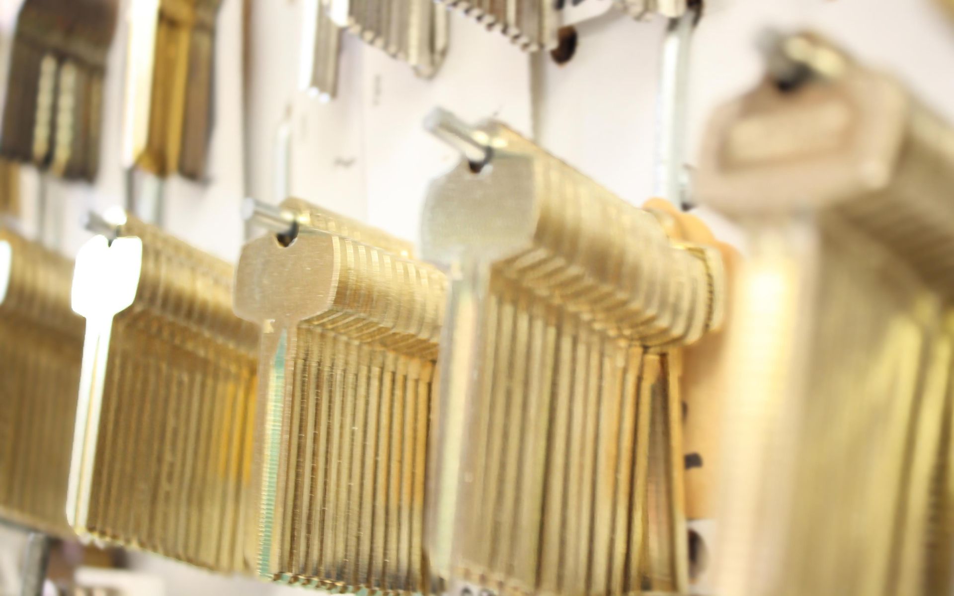 Rows of brass keys hanging on a wall, in a locksmith's shop.