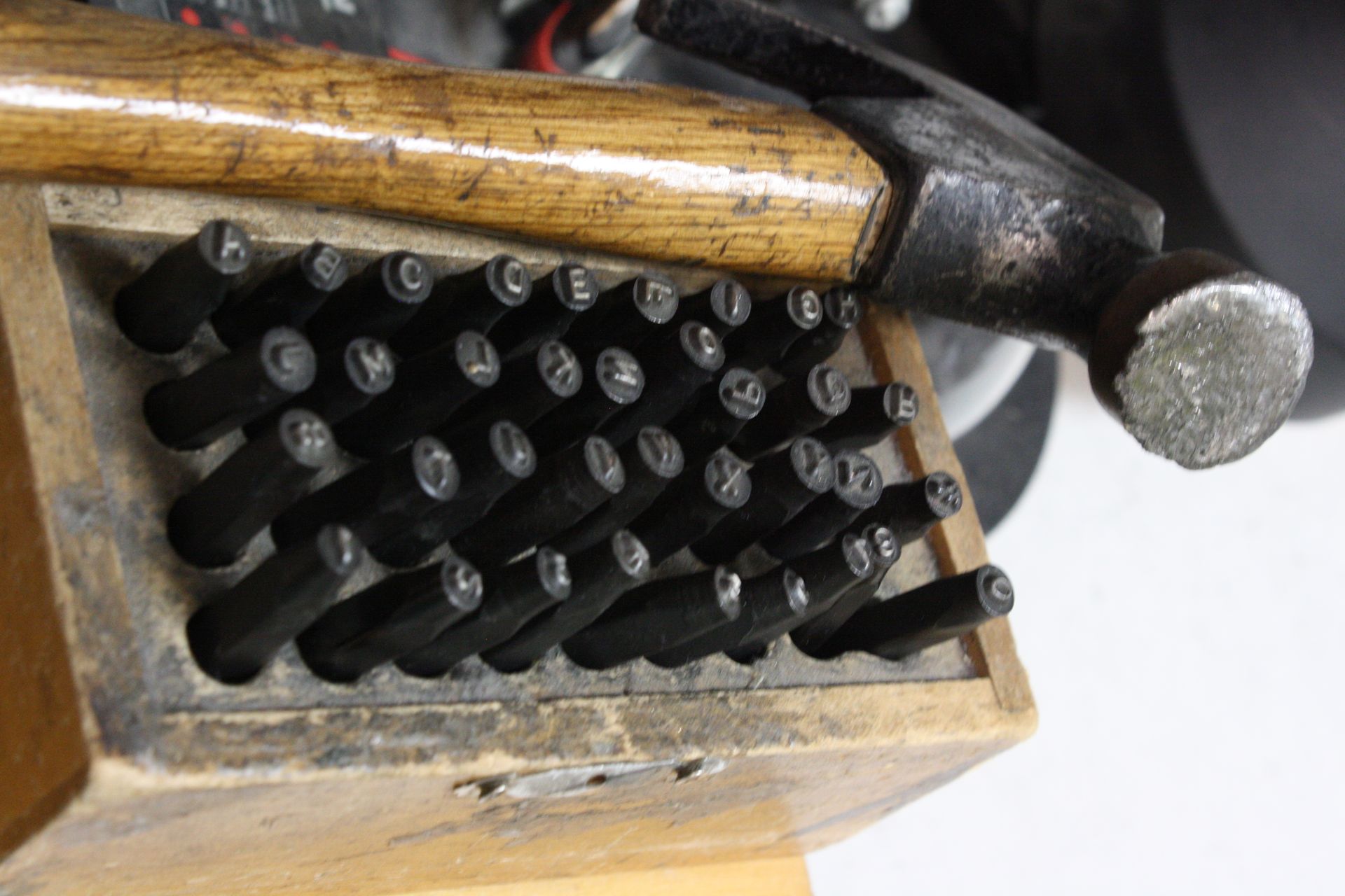 Wooden block with letter stamps, hammer resting on top.