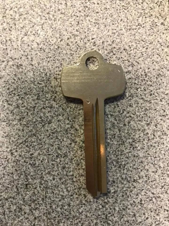 Silver key on a speckled gray surface.