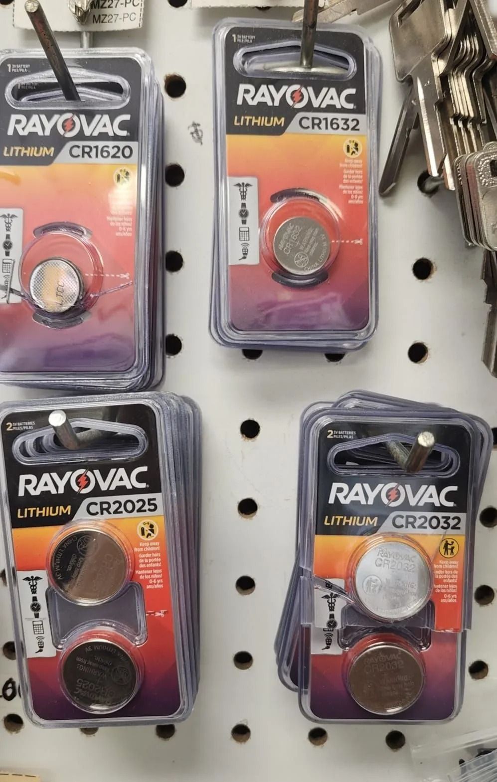 Four packs of Rayovac Lithium batteries on a pegboard: CR1620, CR1632, CR2025, and CR2032.