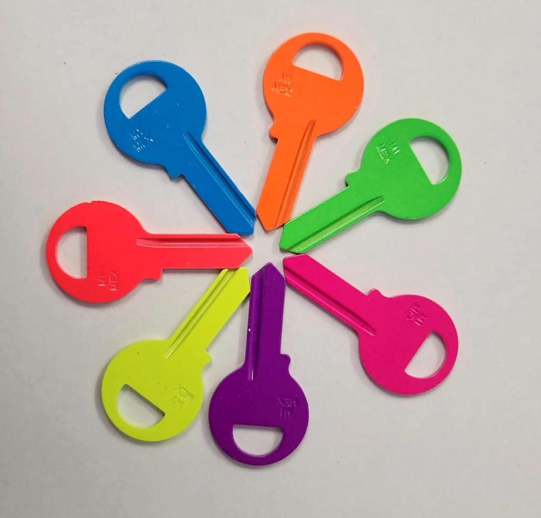 Seven brightly colored keys arranged in a circular pattern on a white surface.