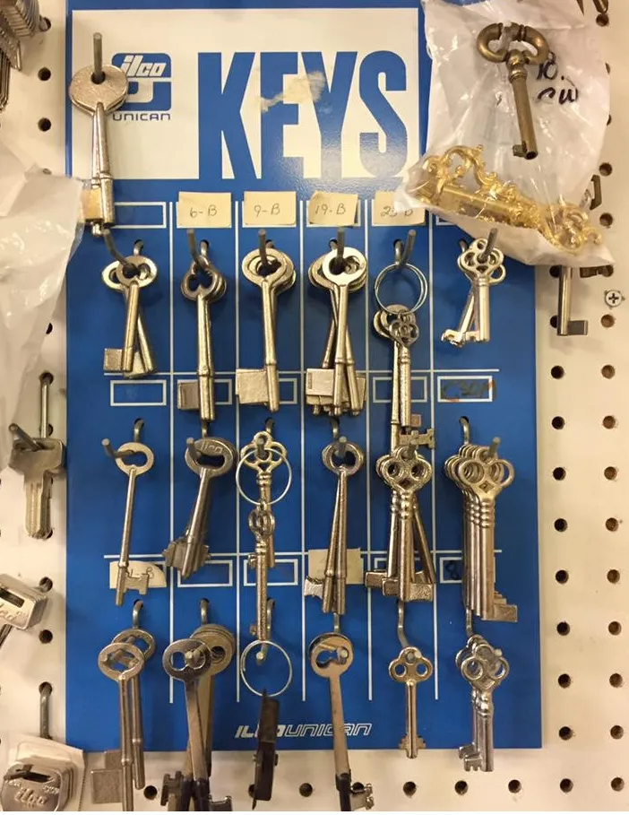 Blue pegboard display of various antique keys.