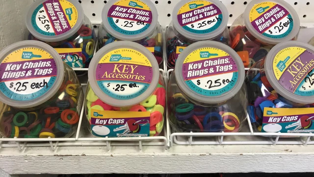 Shelves displaying jars of colorful keychains, rings, and tags, priced at $0.25 each.