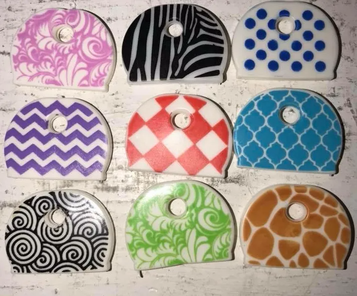 Nine decorative key covers in various patterns and colors: zebra stripes, polka dots, chevron, etc.