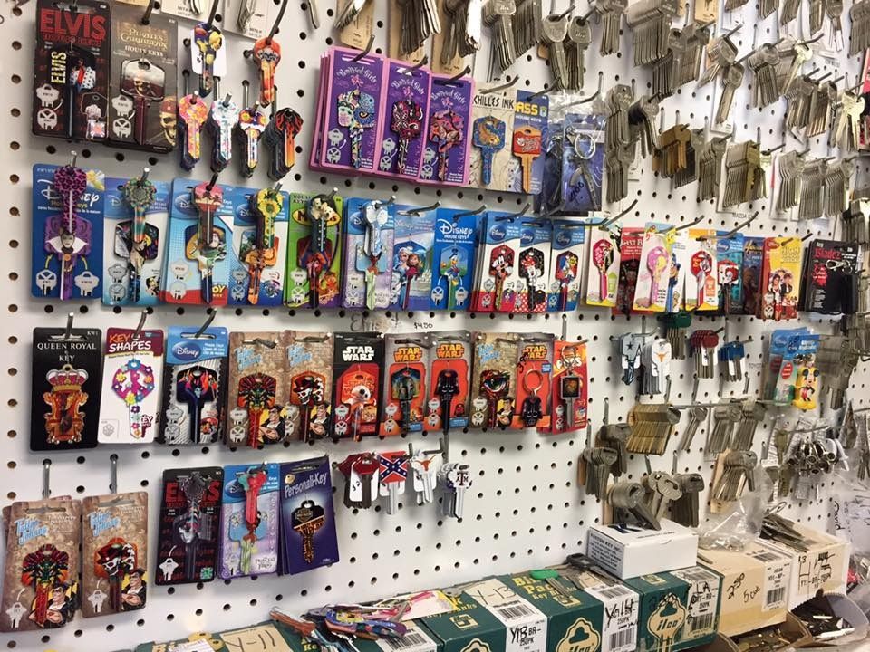 A display of packaged decorative keys on a pegboard wall, with many other keys hanging nearby