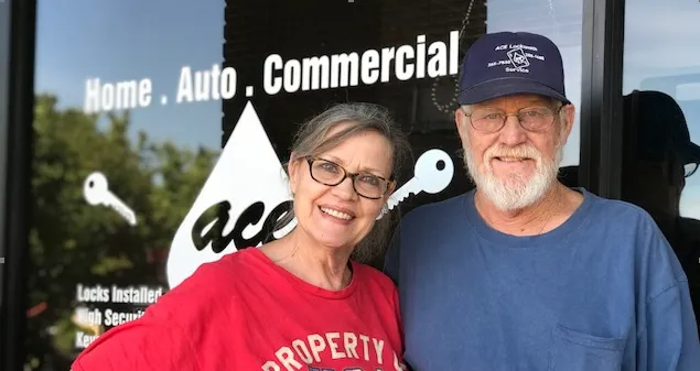 Smiling couple in front of ACE Locksmith Services, LLC store