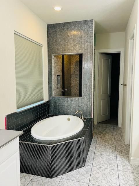 A bathroom with a bathtub and a mirror