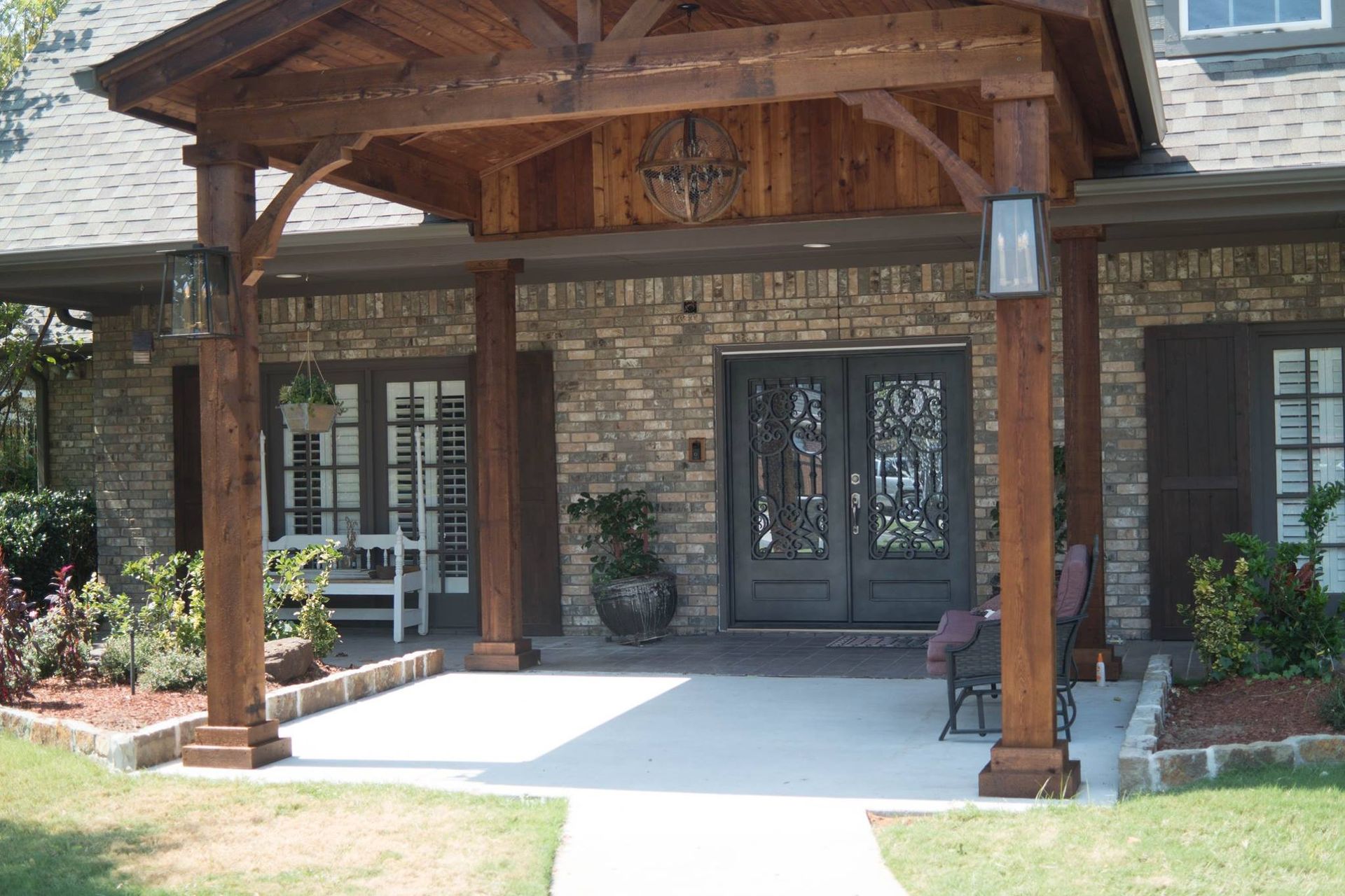 A brick house with a wooden porch over the front door