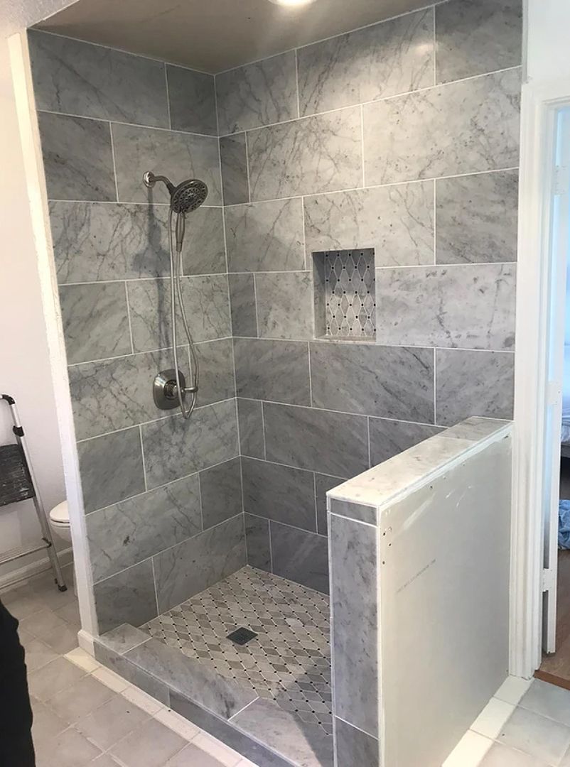 A bathroom with a walk in shower and a toilet.