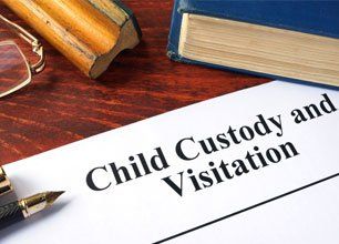 Child Custody and Visitation written on a paper and a book