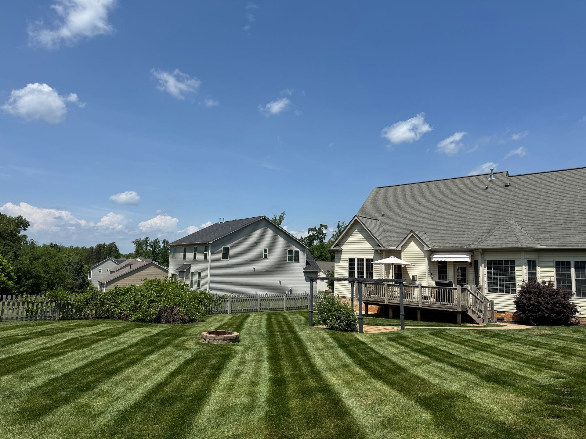A lush green lawn in front of a house on a sunny day.