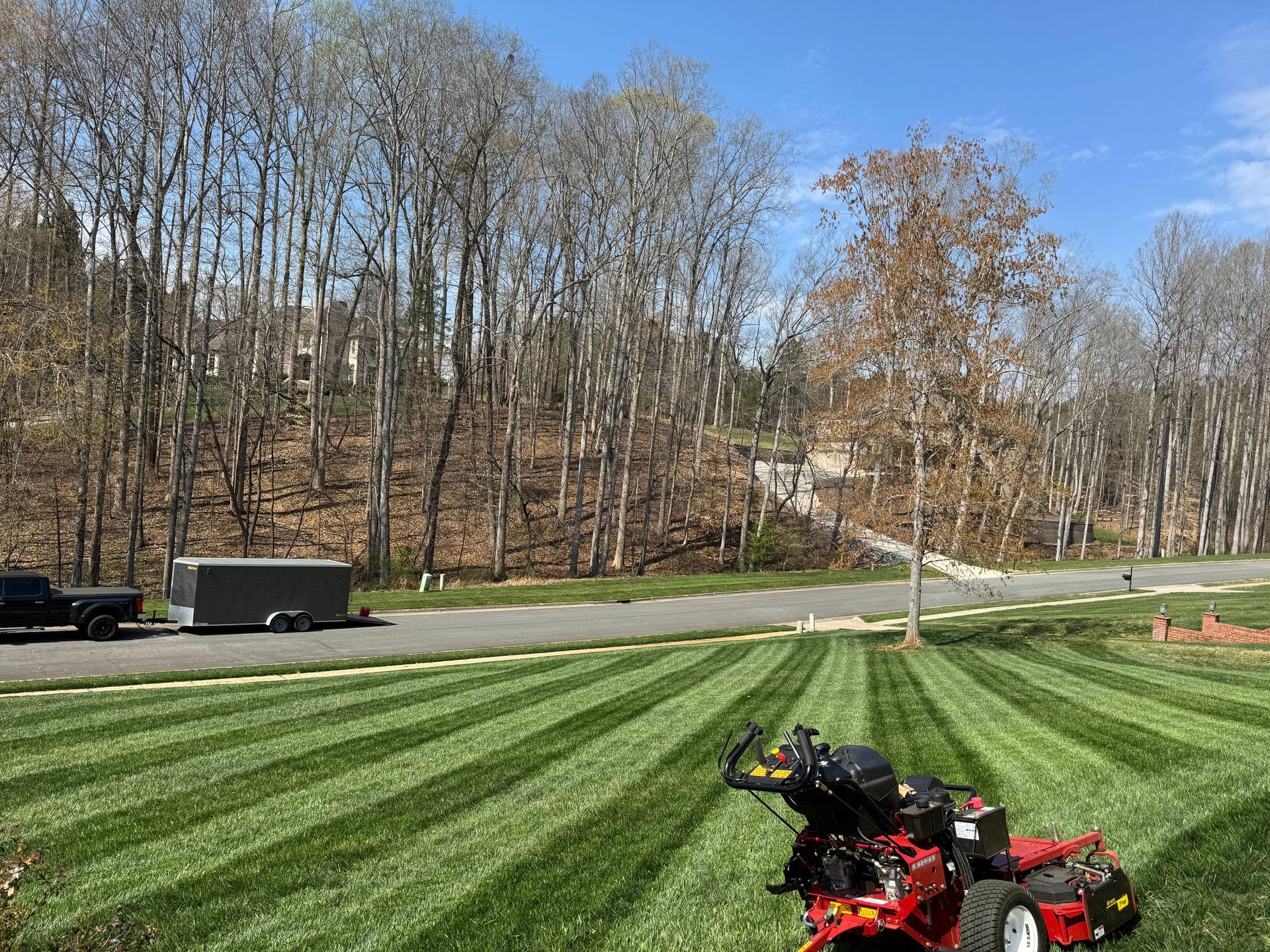 A lawn mower is sitting in the middle of a lush green lawn.