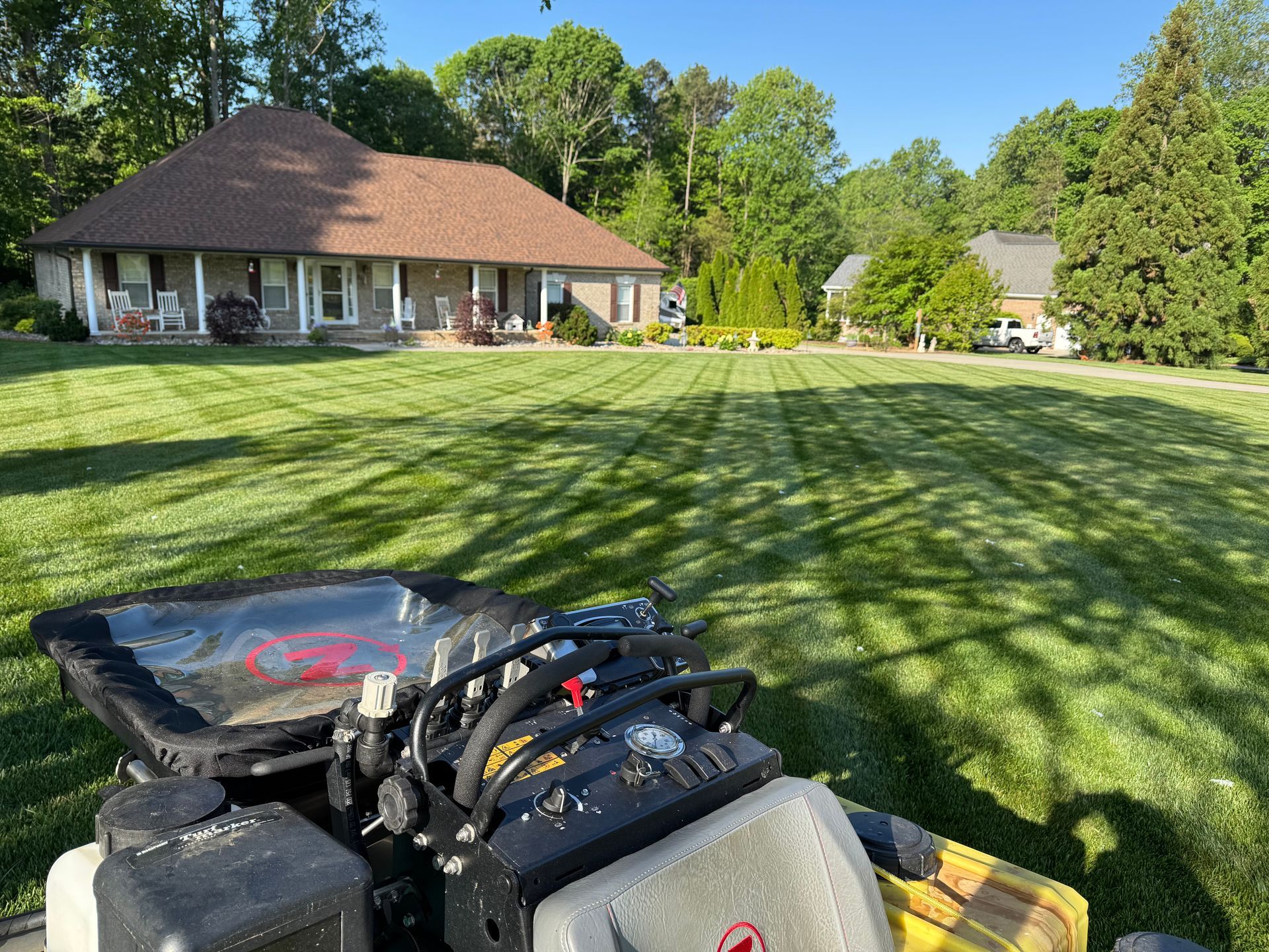 A lawn mower is parked in front of a house.