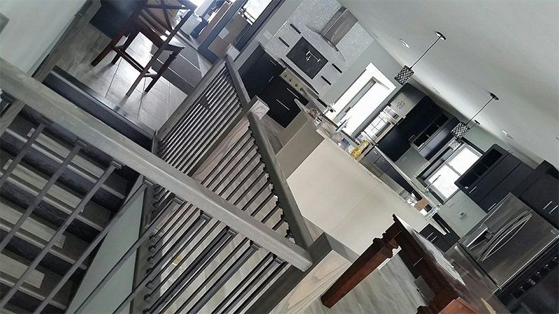 Tilted view of a modern office interior with desks, stairs, and large windows