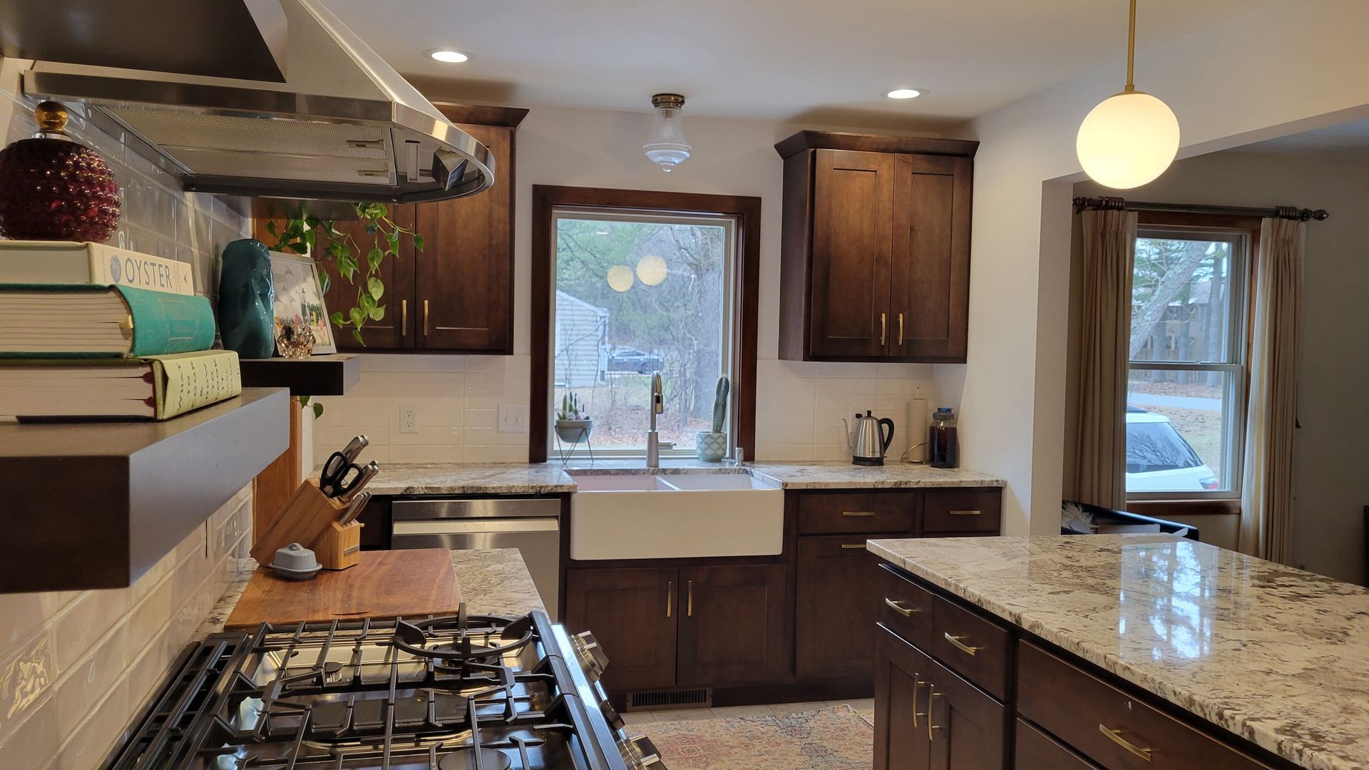 Kitchen with dark wood cabinets, white countertops, farmhouse sink, and a center island with granite.