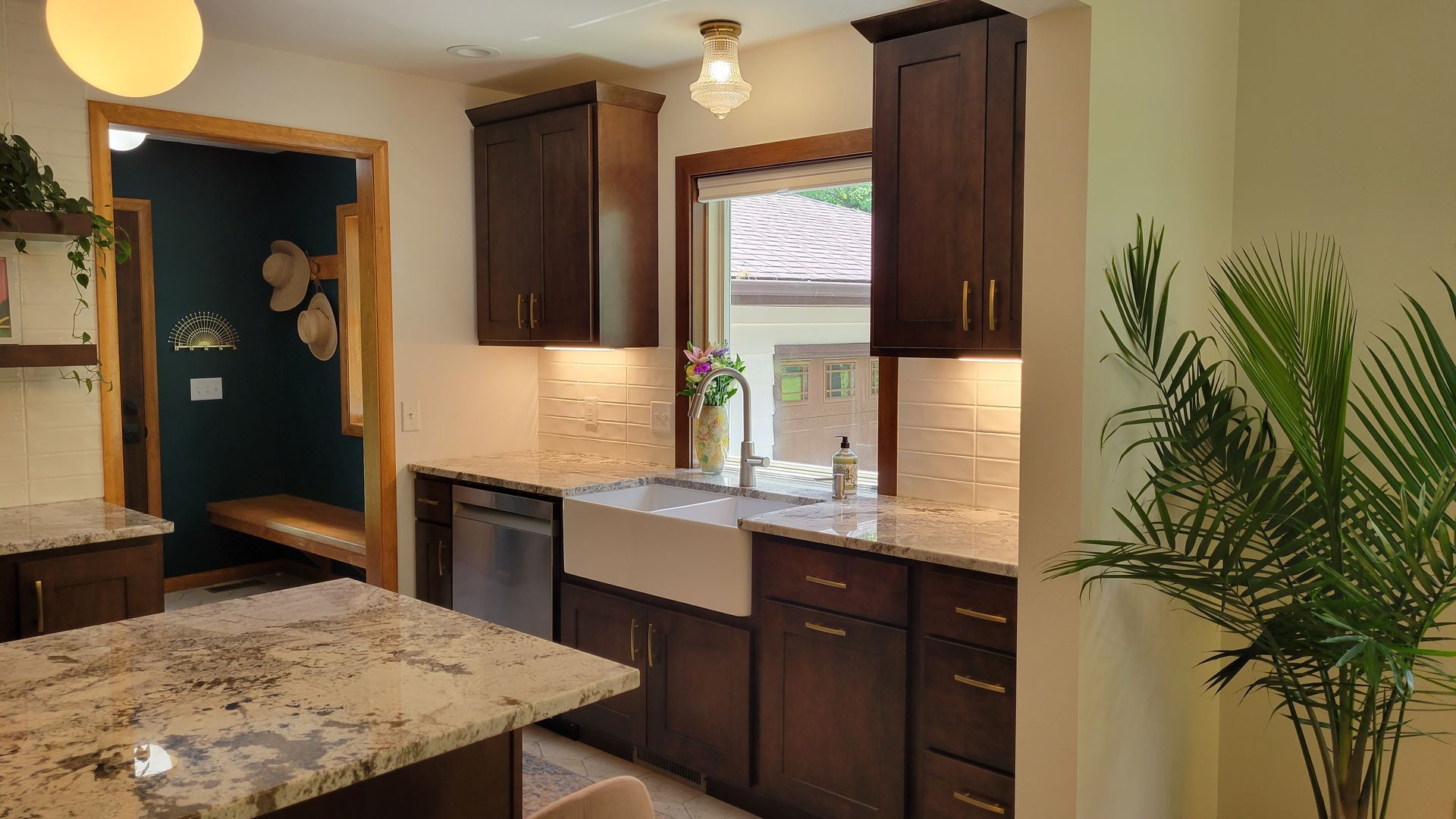 Kitchen with dark cabinets, white farmhouse sink, and granite countertops.