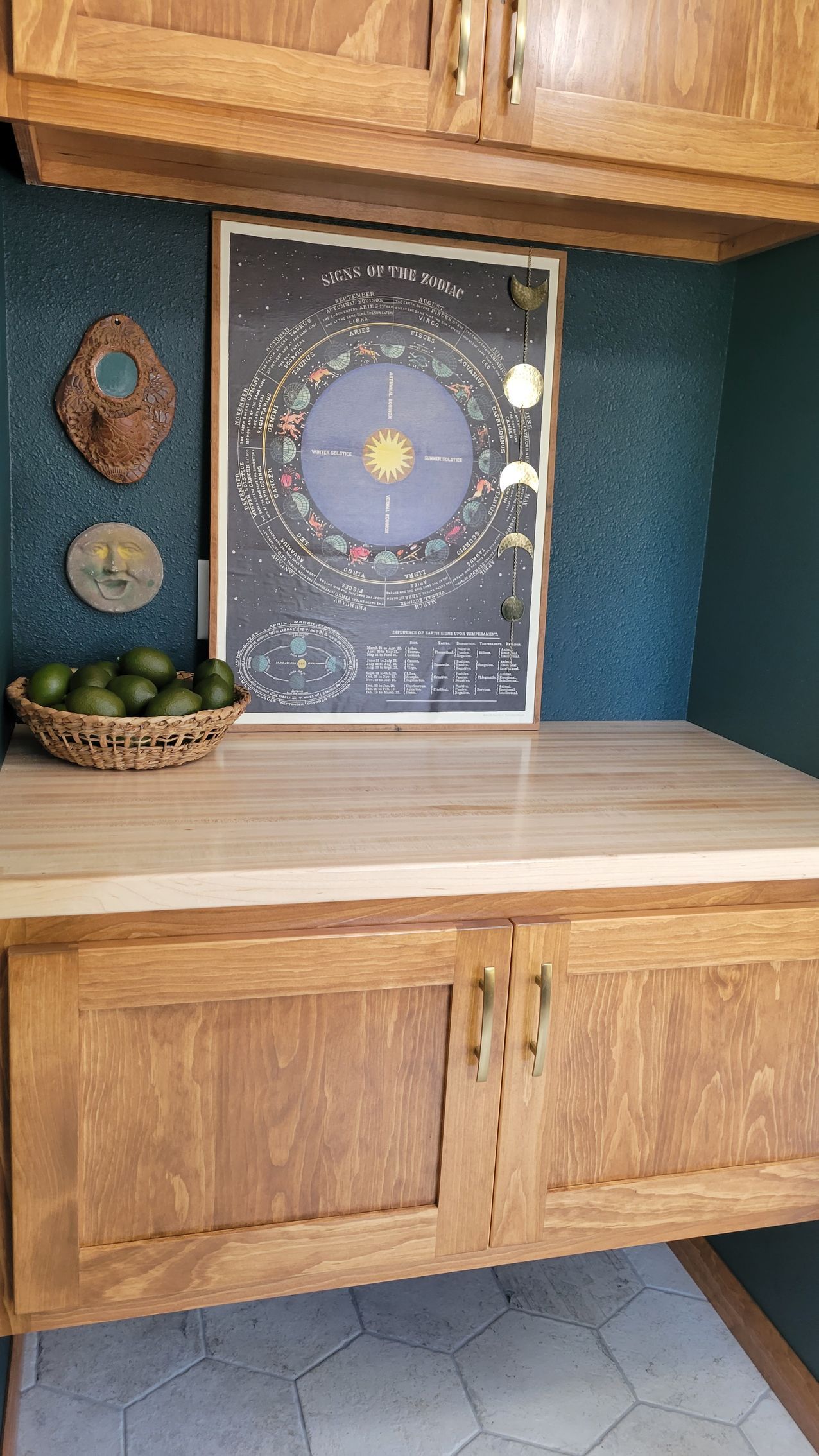 Kitchen with wood cabinets, countertop, a solar system poster, and avocados.