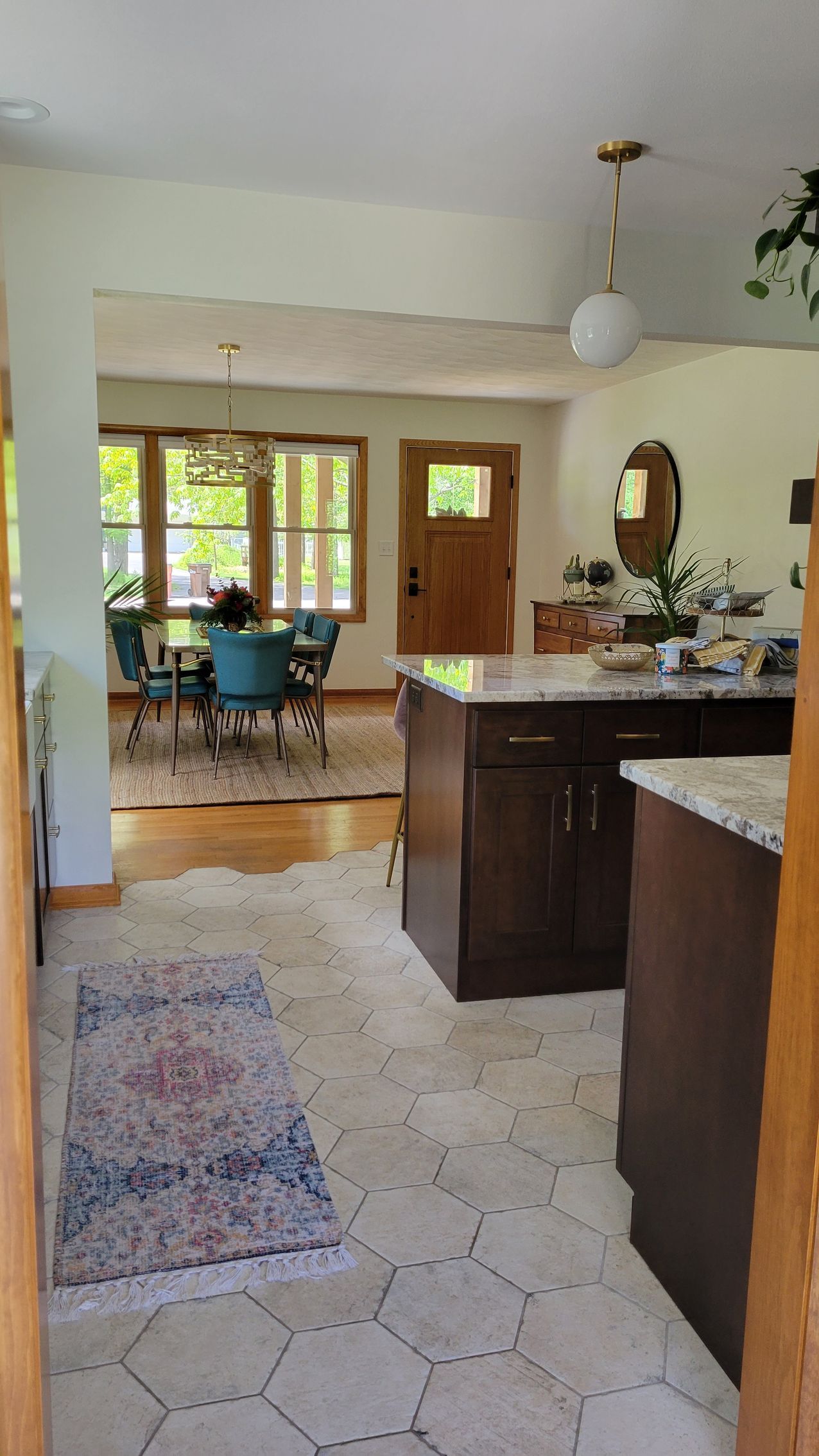 Kitchen with island, open to dining area, hardwood floors, hexagon tile, entry door.