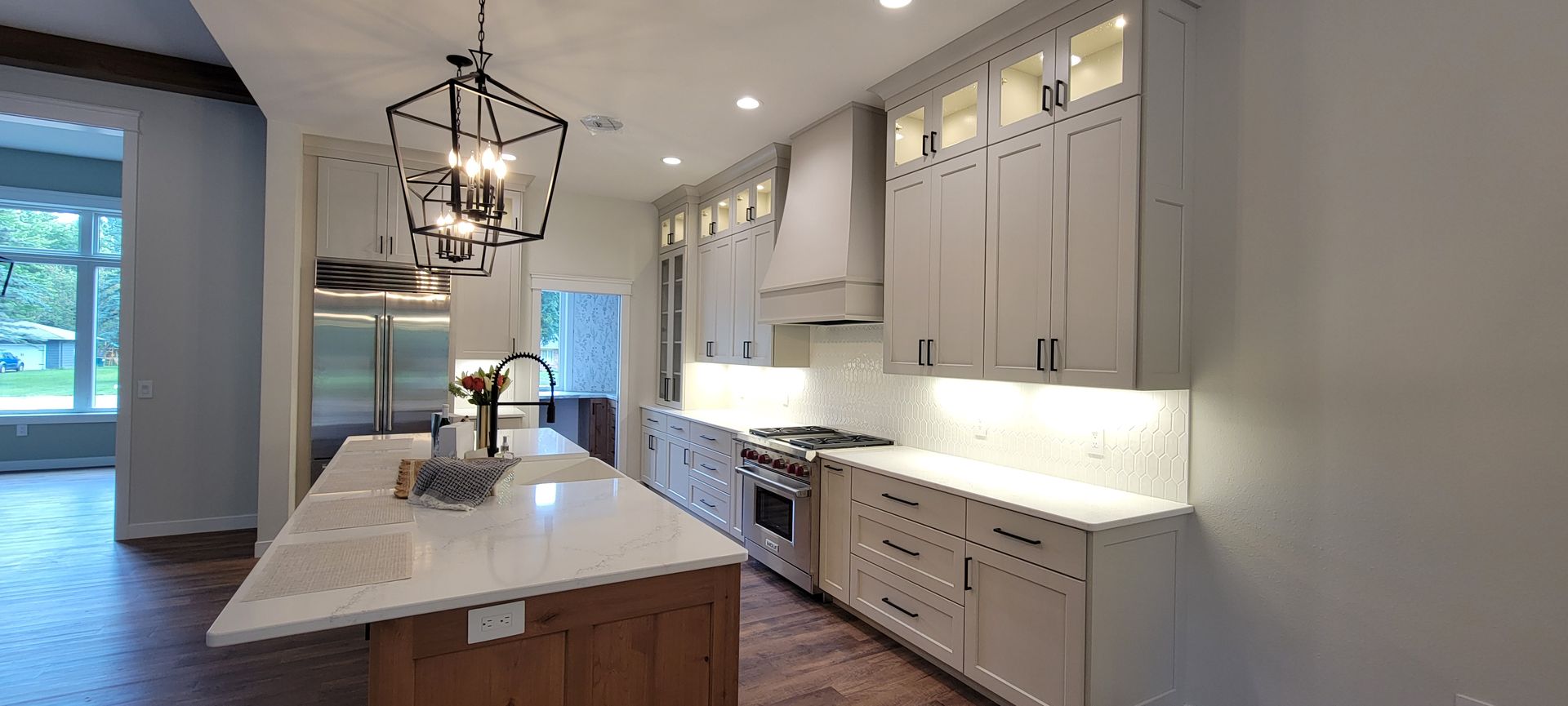 Modern kitchen with a large island, stainless steel appliances, and light cabinetry.