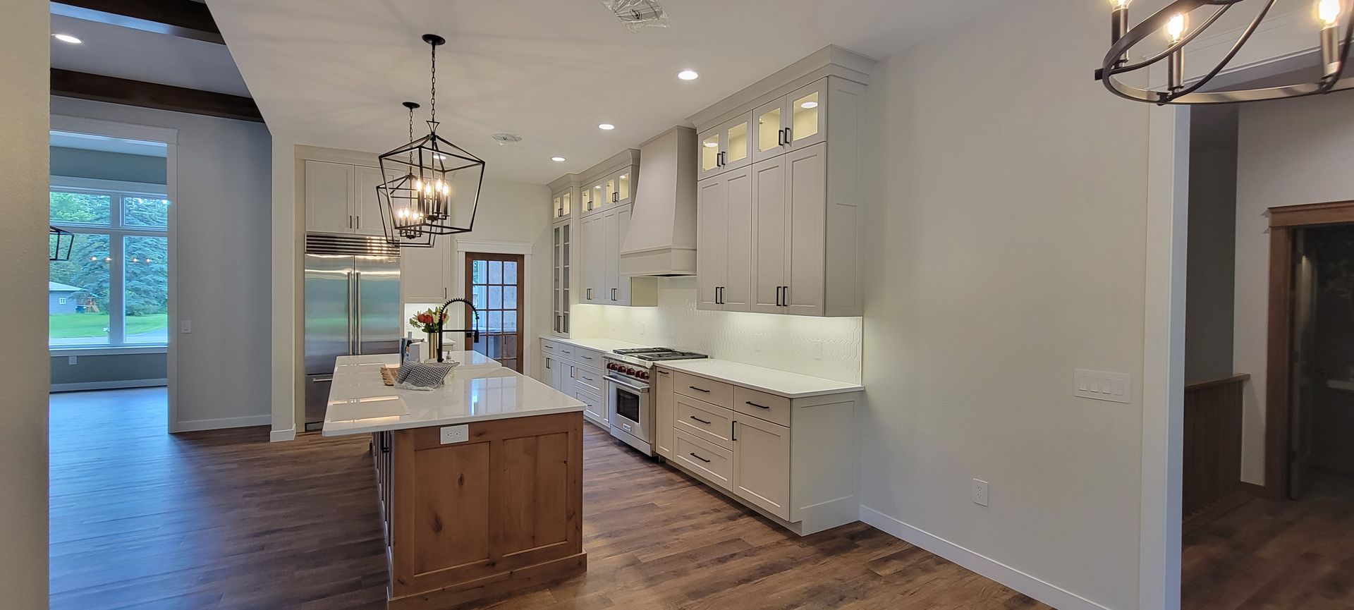 Kitchen with a wooden island, white cabinets, and stainless steel appliances.