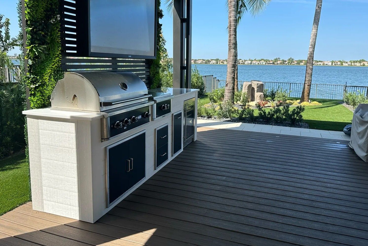 Outdoor kitchen with grill and cabinets on a patio overlooking the ocean