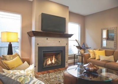Cozy living room with fireplace, beige walls, yellow accents, and a glass coffee table