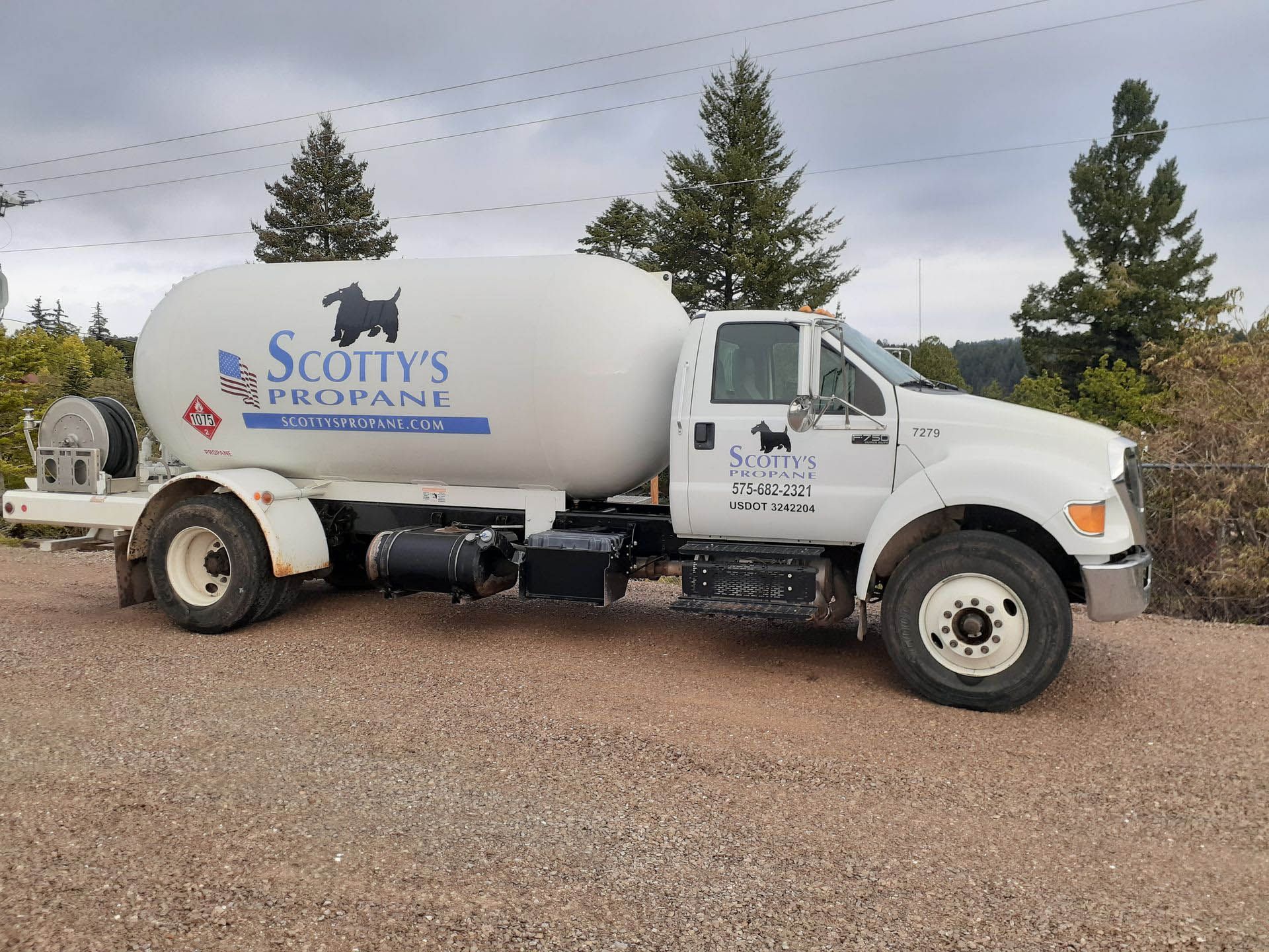 A man is standing in front of a Scotty's Propane truck.