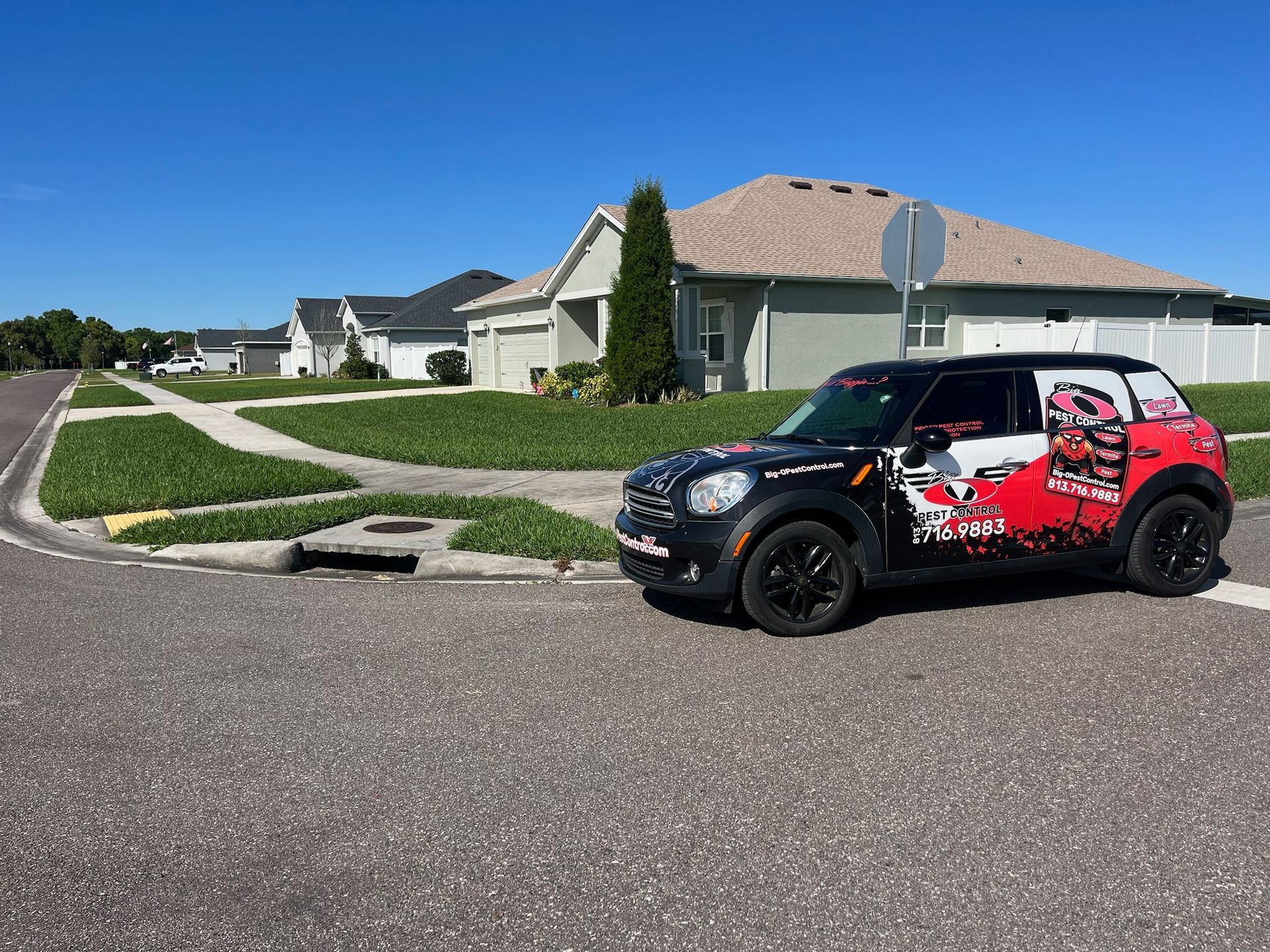 A black and red mini cooper is parked in front of a house
