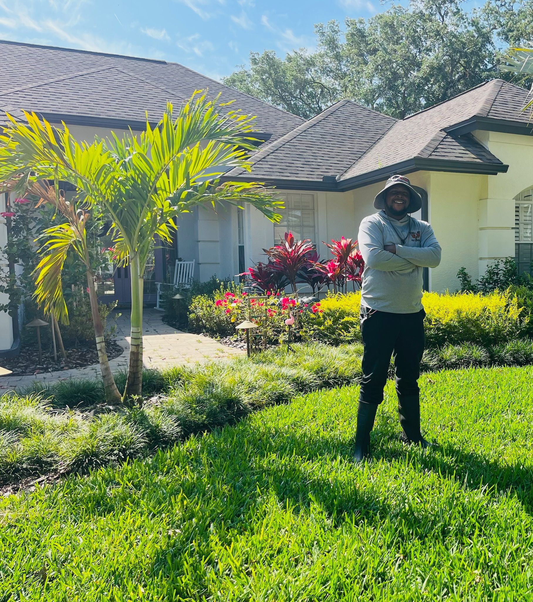 A man is standing in the grass in front of a house.