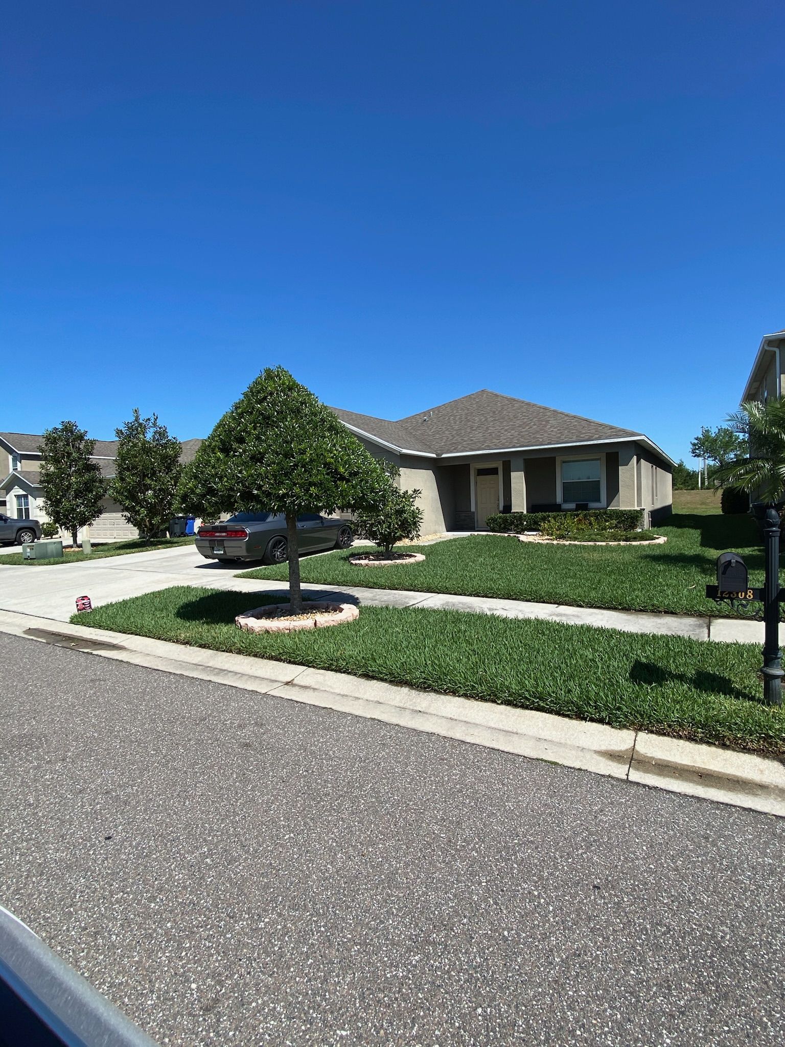 A house with a car parked in front of it in a residential area.