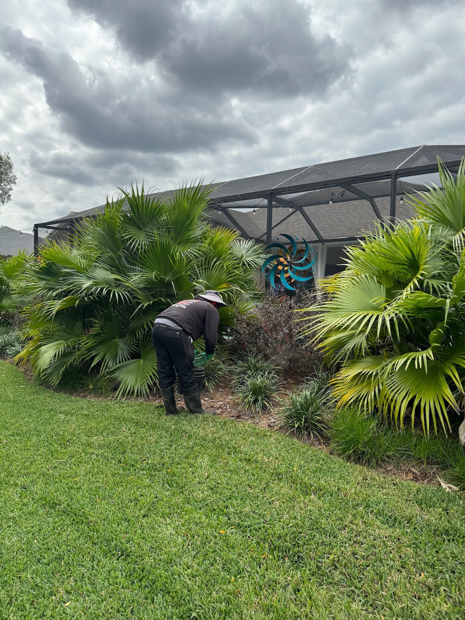 A man is working in a garden in front of a house.