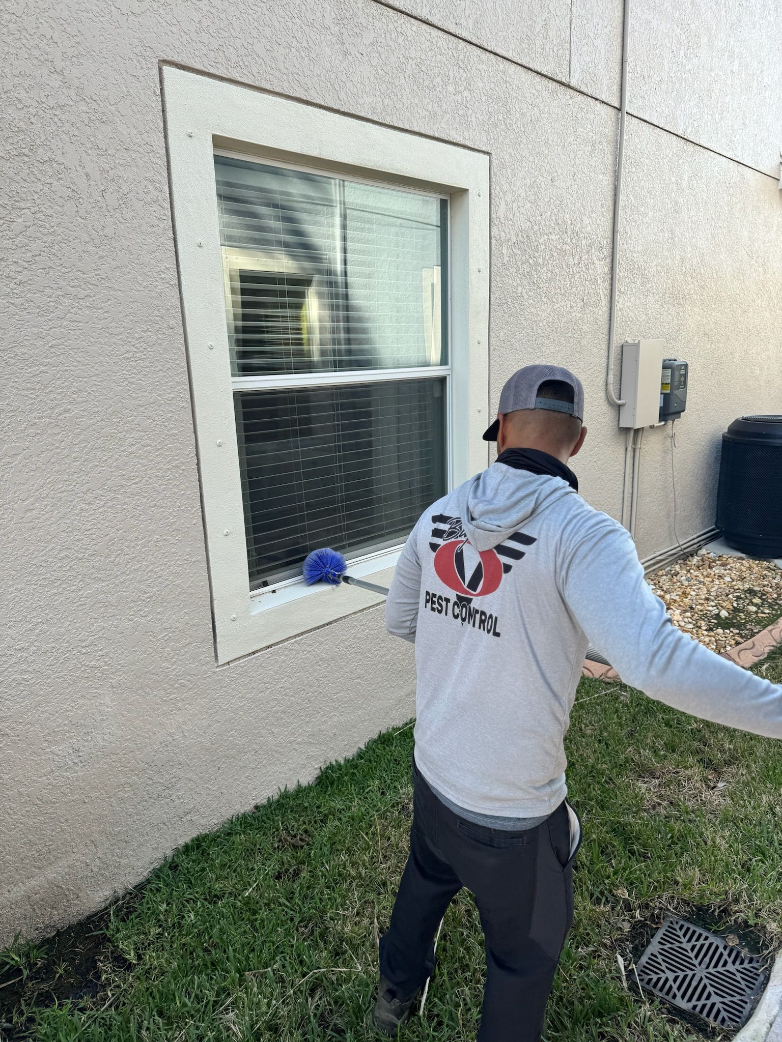 A man is standing in front of a window on the side of a building.