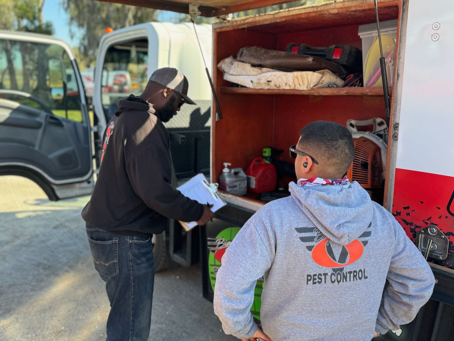 Two men are standing next to each other in front of a truck.