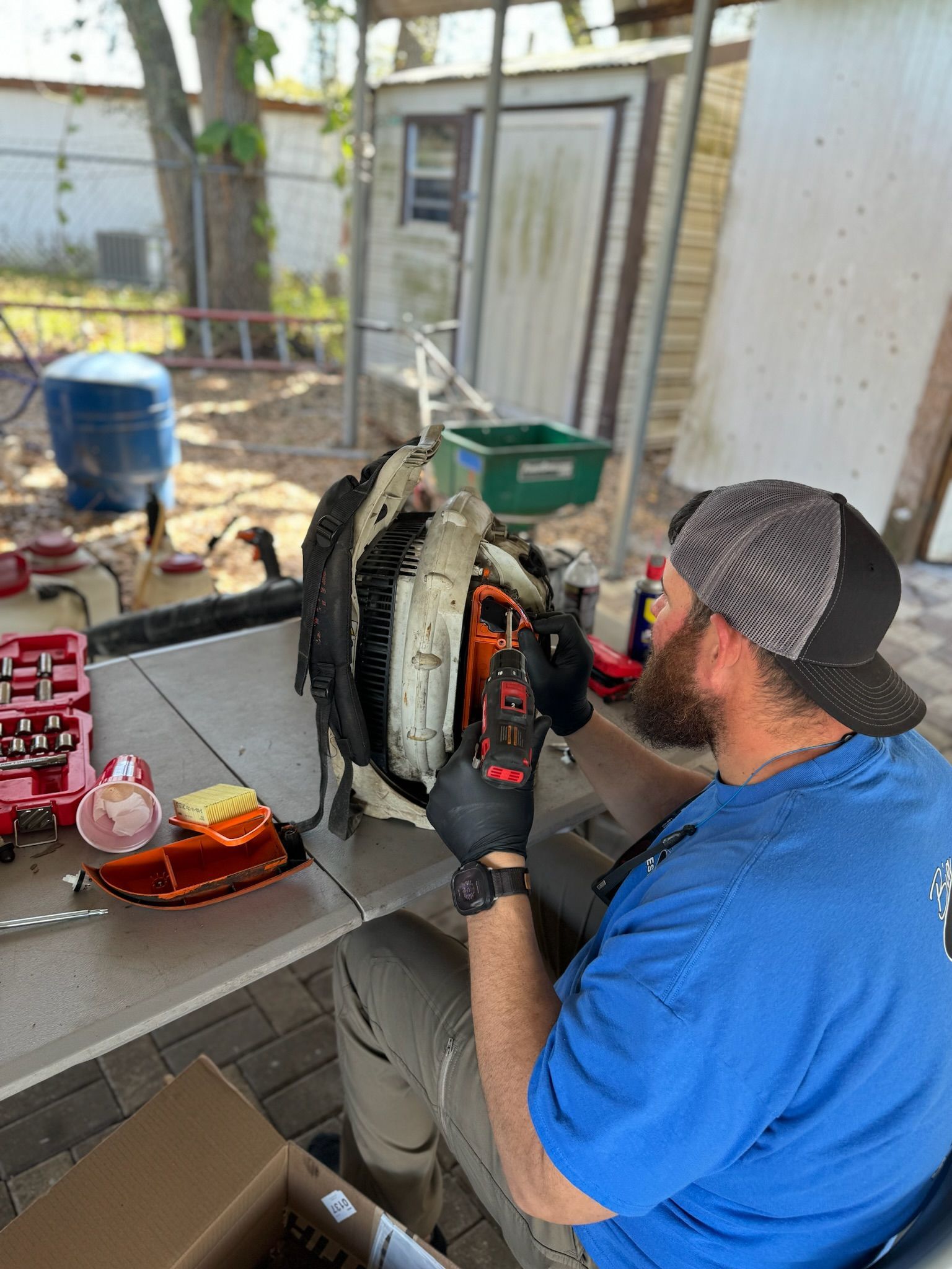 A man is sitting at a table working on a lawn mower.