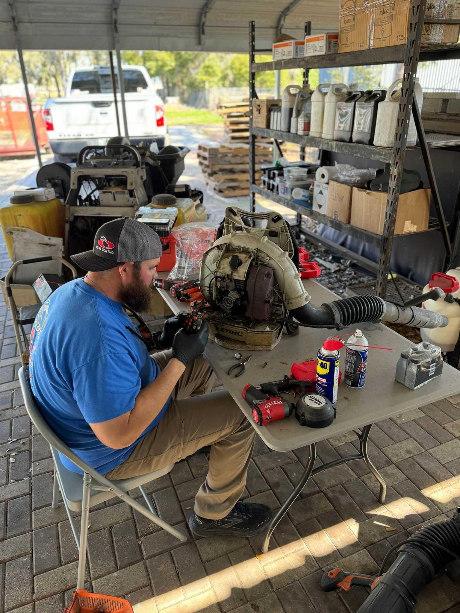 A man is sitting at a table working on a machine.