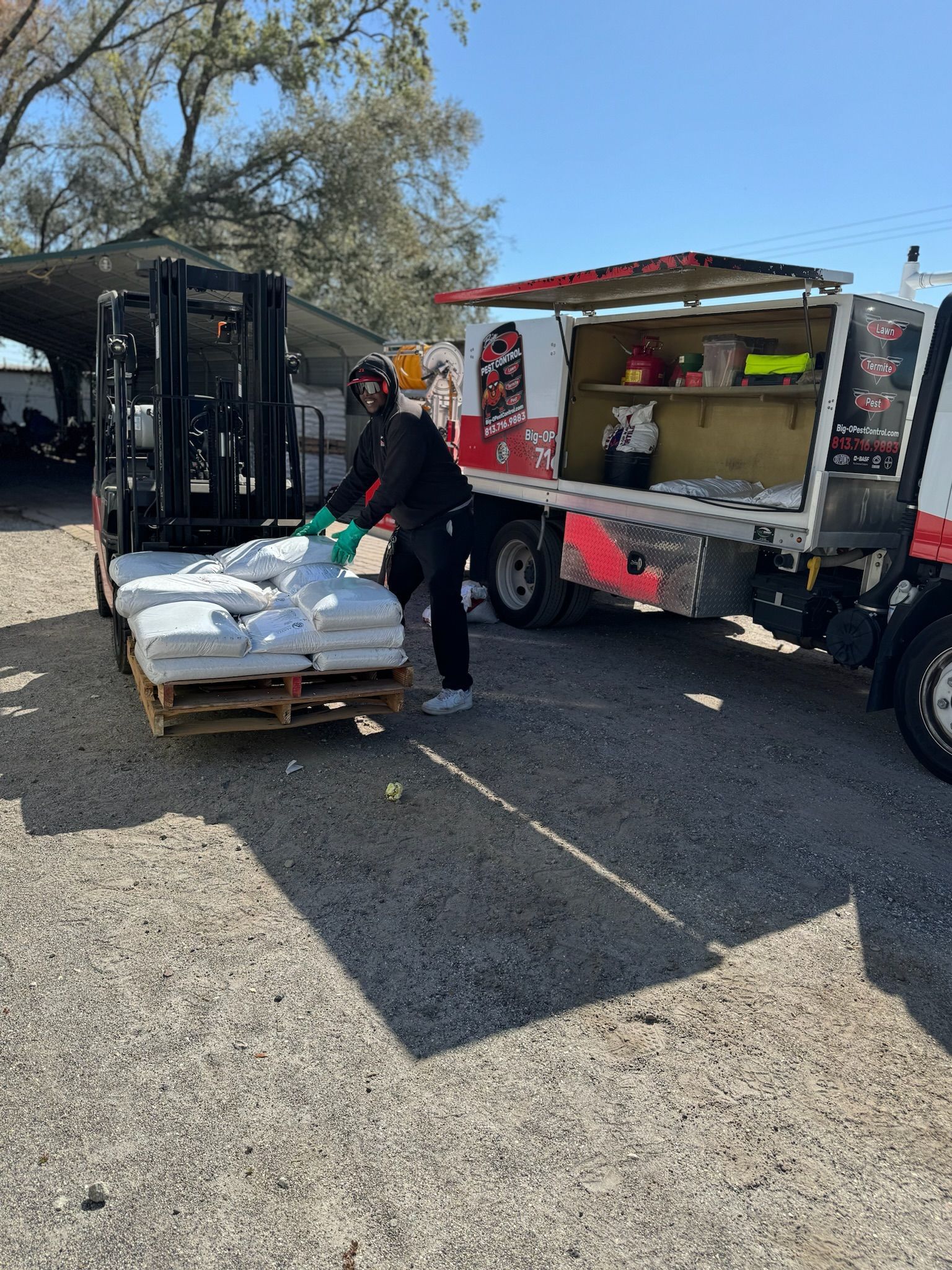 A man is loading bags onto a pallet in front of a truck.