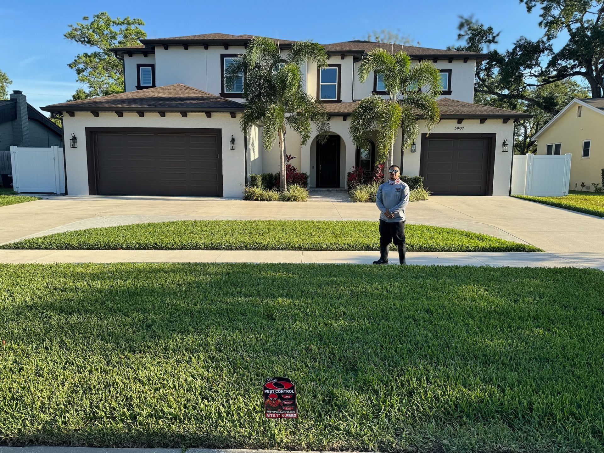 A man is standing in front of a large house