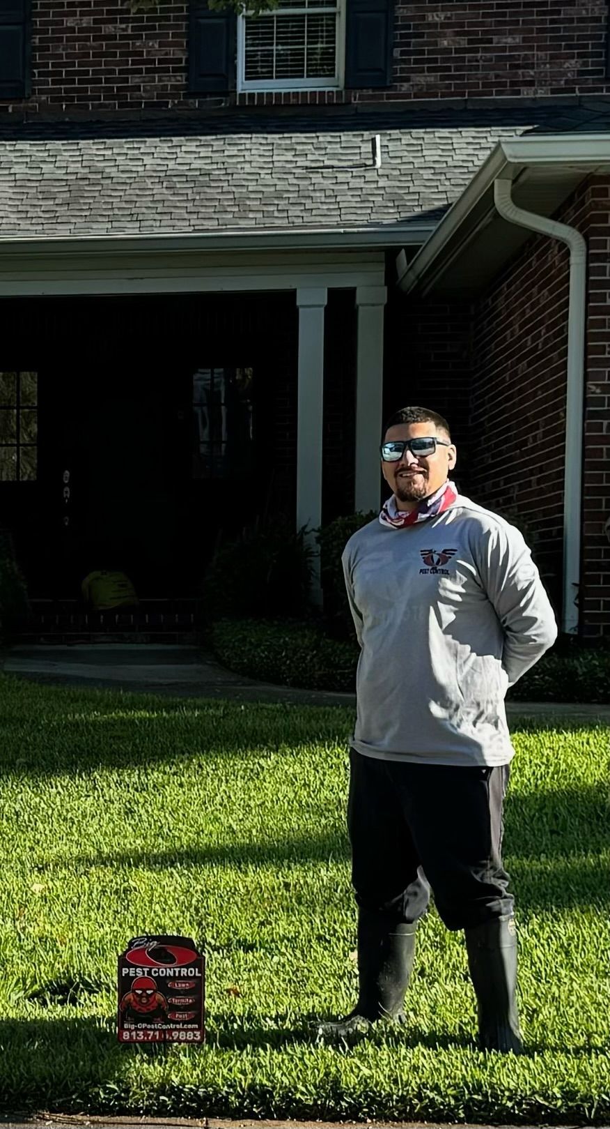 A man is standing in the grass in front of a house.