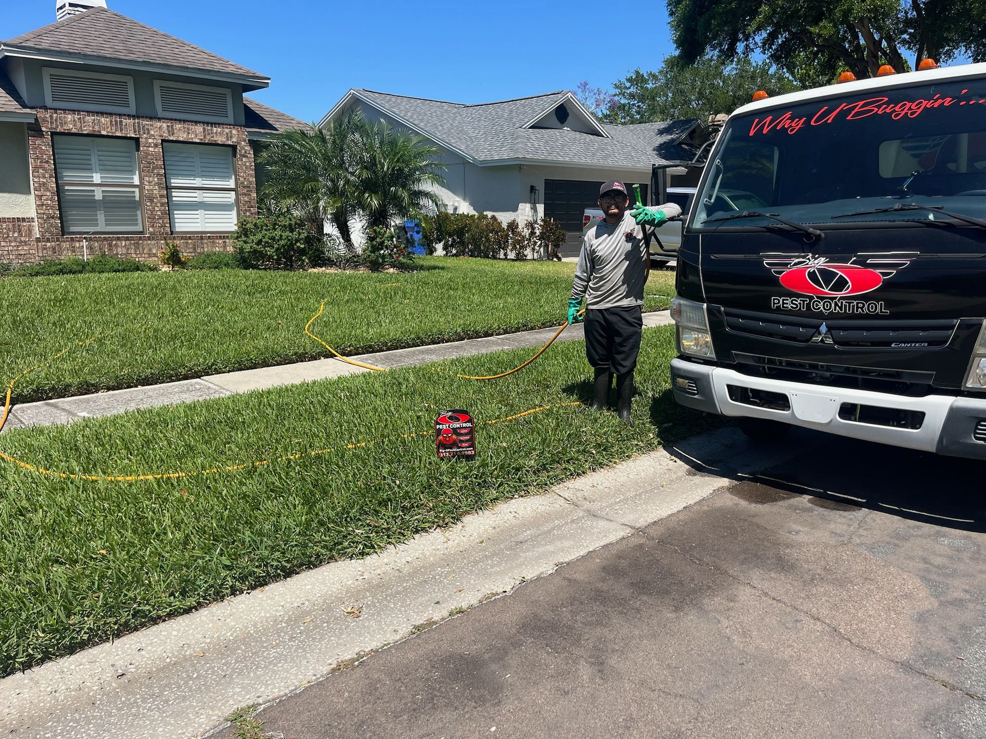 A man is standing next to a truck in front of a house.