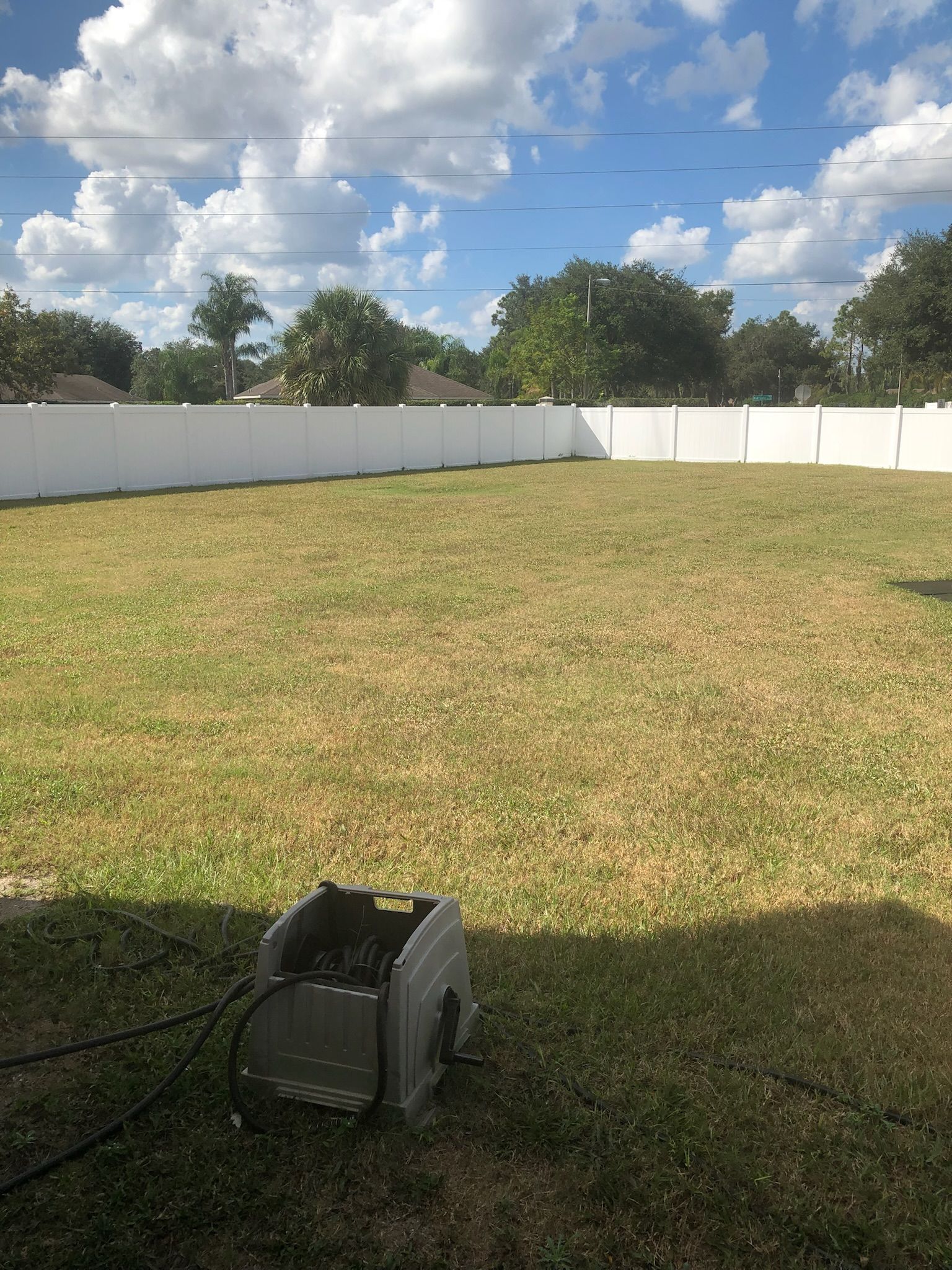 A lawn mower is sitting in the middle of a lush green field.