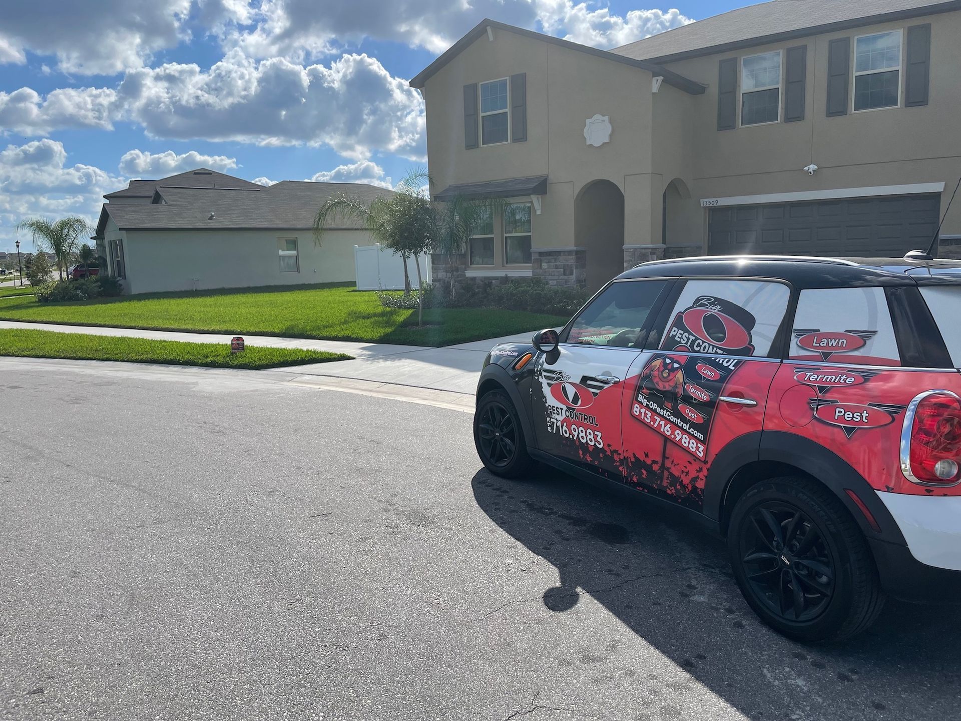 A red and white mini cooper is parked in front of a house.